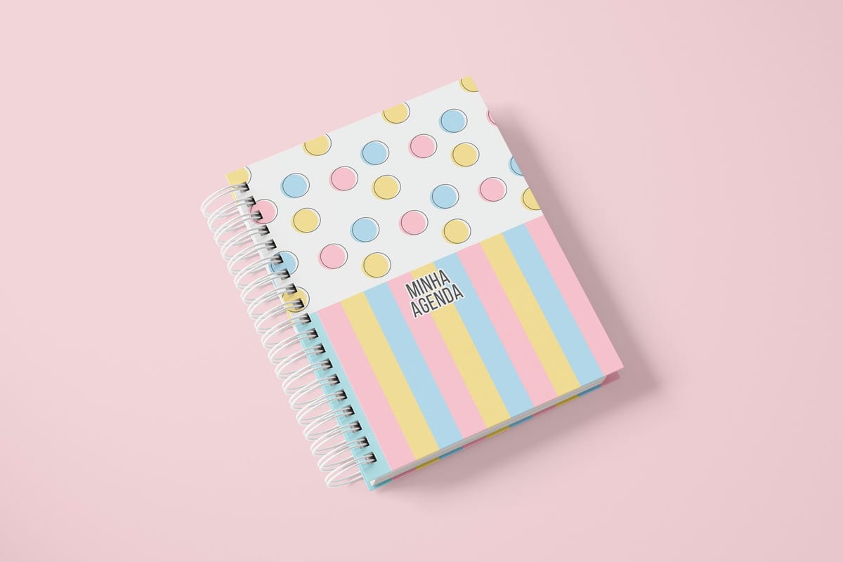 Agenda Permanente Digital 1 Dia por Página para Imprimir 1 Agenda espiral com capa de bolinhas e listras coloridas, sobre fundo rosa claro. Arte digital.