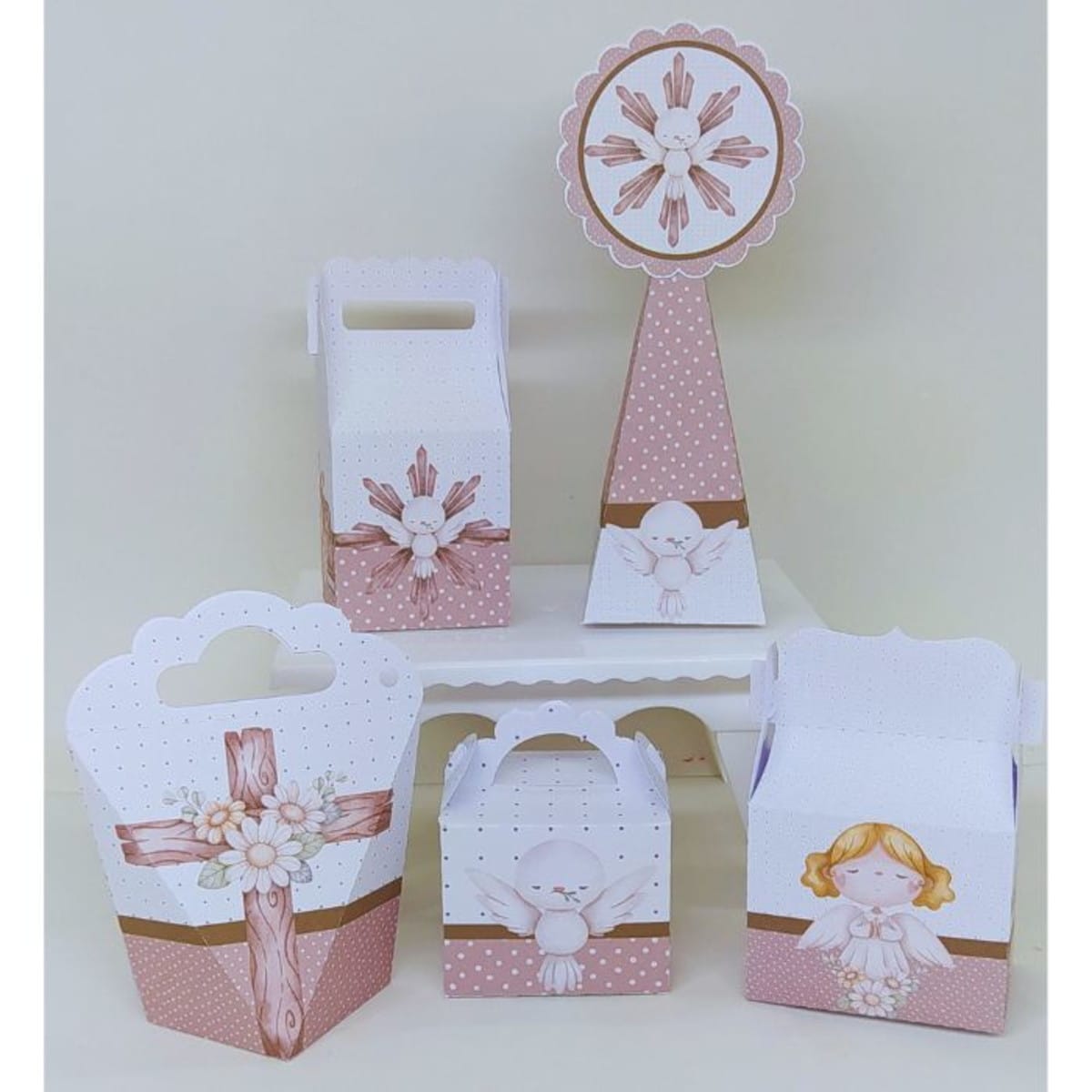 Arquivo de Corte Batizado Branco e Marrom Studio PDF 1 Conjunto de caixas de papel decoradas com temas religiosos em tons rosa e branco.