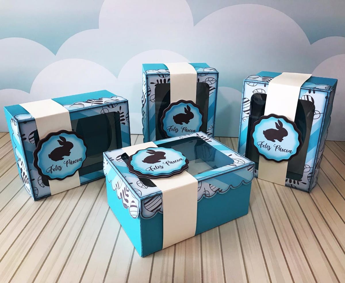 Arquivo de Corte Caixa Ovo de Páscoa 50g a 350g 1 Quatro caixas de Páscoa digitais azuis e brancas com coelho e "Feliz Páscoa".