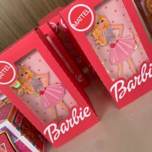Caixinhas rosa decoradas com boneca loira e fundo estampado em tons rosados.