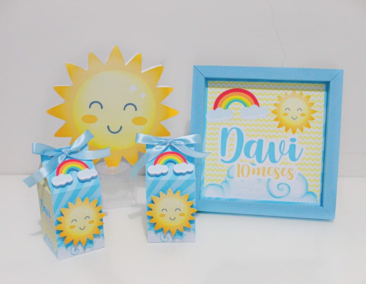 Arquivo de Corte Festa Raio de Sol em Studio e PDF 1 Decoração de mesa com tema de sol, nuvens, arco-íris e moldura azul.