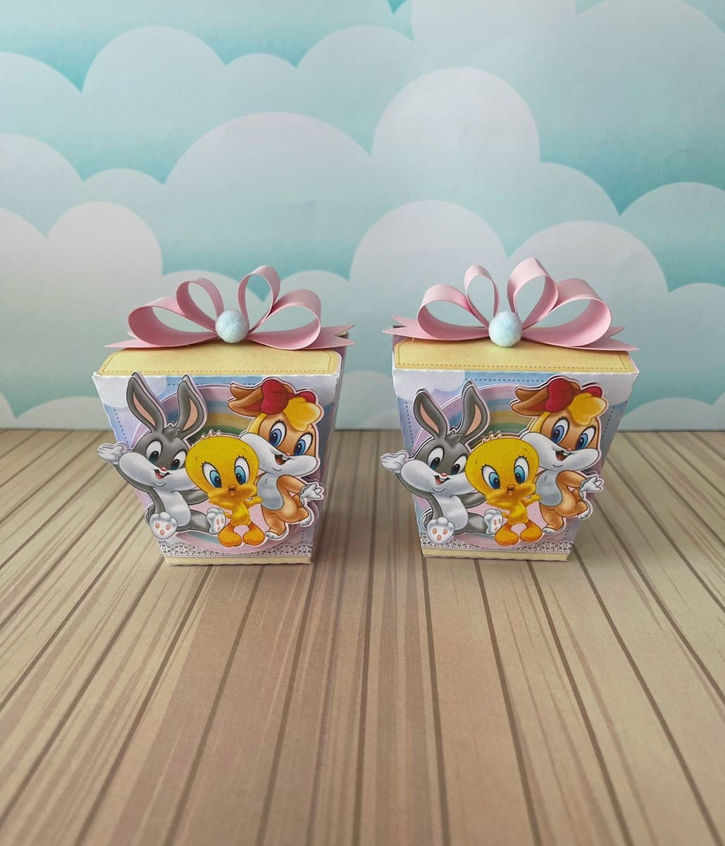 Arquivo de Corte Looney Tunes Rosa para Festa Studio e PDF 4 Duas caixas decoradas com personagens infantis e laço rosa sobre superfície de madeira