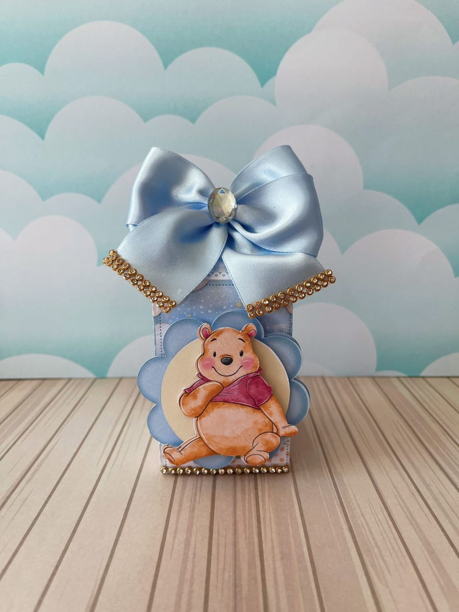 Arquivo de Corte Ursinho Pooh Menino para Festa Infantil 4 Caixa decorativa com urso sentado, laço azul e detalhes em pedrarias brilhantes.