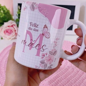 Mão segurando caneca branca decorada com estampa rosa de flores e borboleta
