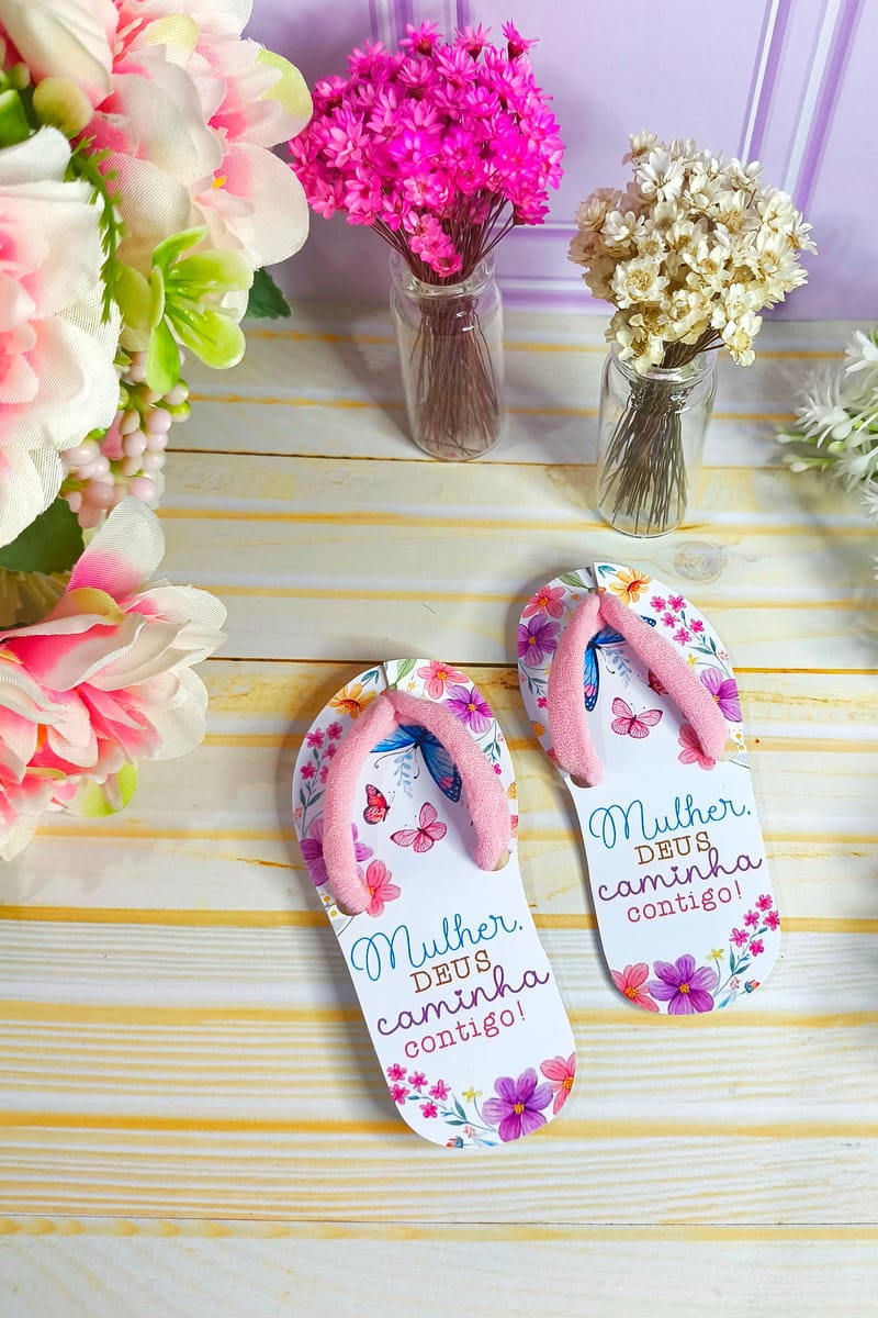 Arquivo Digital Chinelinho Xuxinha Feminino Floral 1 Sandálias decoradas com estampas florais e frases inspiradoras sobre fundo de madeira.
