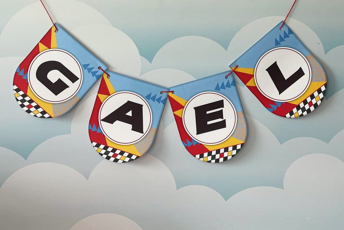Arquivo Digital Festa Carros Disney para Corte e Impressão 4 Bandeirinhas decorativas com letras presas por um fio sobre fundo de nuvens azuladas.