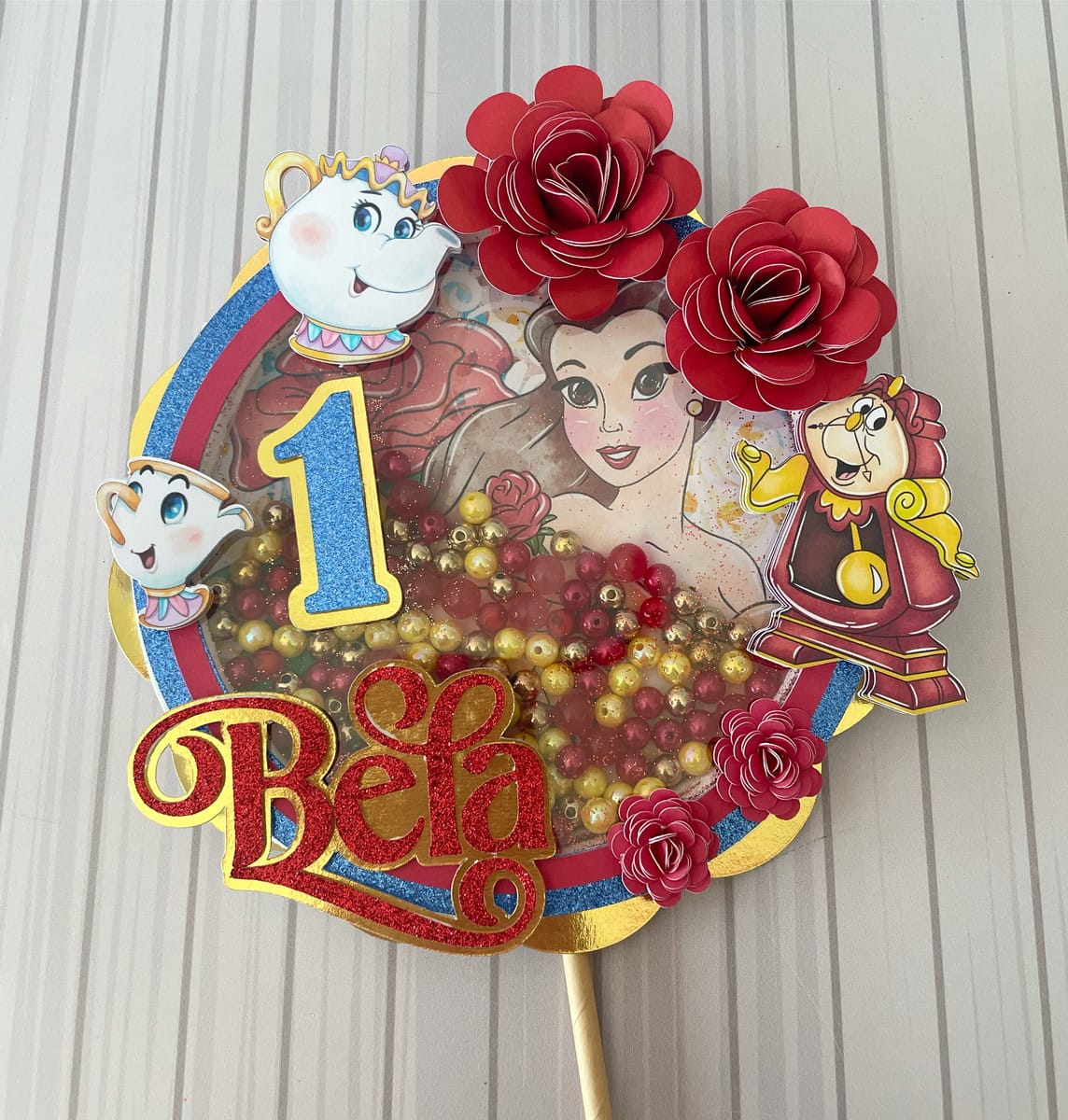 Arquivo Digital Festa Luxo Bela e a Fera para Imprimir 2 Topo de bolo personalizado com desenho de princesa, flores de papel e contas coloridas.
