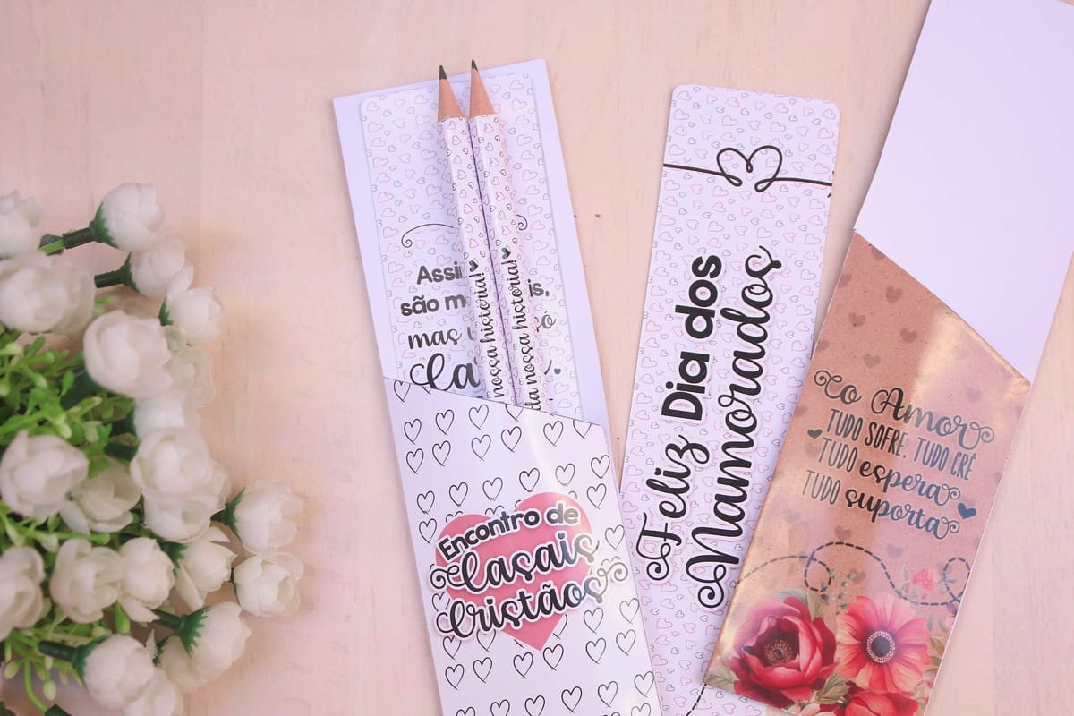 Arquivo Digital Lembrancinha Cristã para Encontro de Casais 1 Dois suportes de papel decorados com corações e lápis impressos sobre fundo claro.