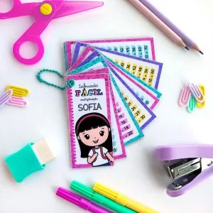Cartões de tabuada coloridos cercados por materiais escolares sobre fundo branco