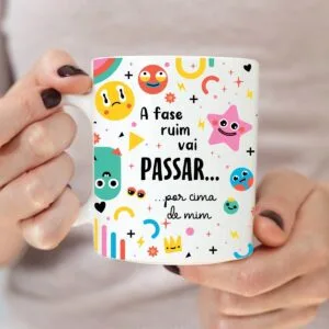 Arte Caneca a Fase Ruim Vai Passar 19 Mãos segurando uma caneca branca estampada com emojis e frases em português.