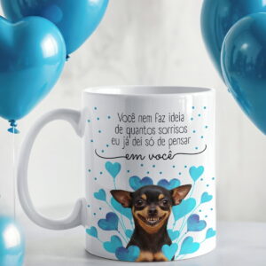 Arte Digital Caneca Pinscher Frase Motivacional Sublimação 36 Caneca branca estampada com cachorro sorrindo e corações azuis ao fundo.