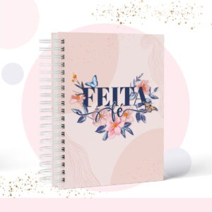 Caderno espiral rosa com estampa floral e borboletas e a frase escrita feita de fé.