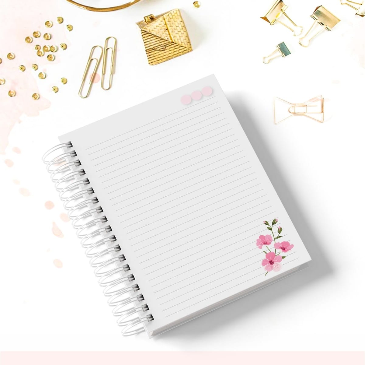 Caderno de Estética Digital Personalizável para Revenda 2 Caderno espiral com linhas e flores rosa decorado com clipes dourados na mesa.