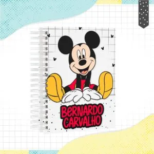 Caderno espiral estampado com desenho de rato sorridente e fundo quadriculado.