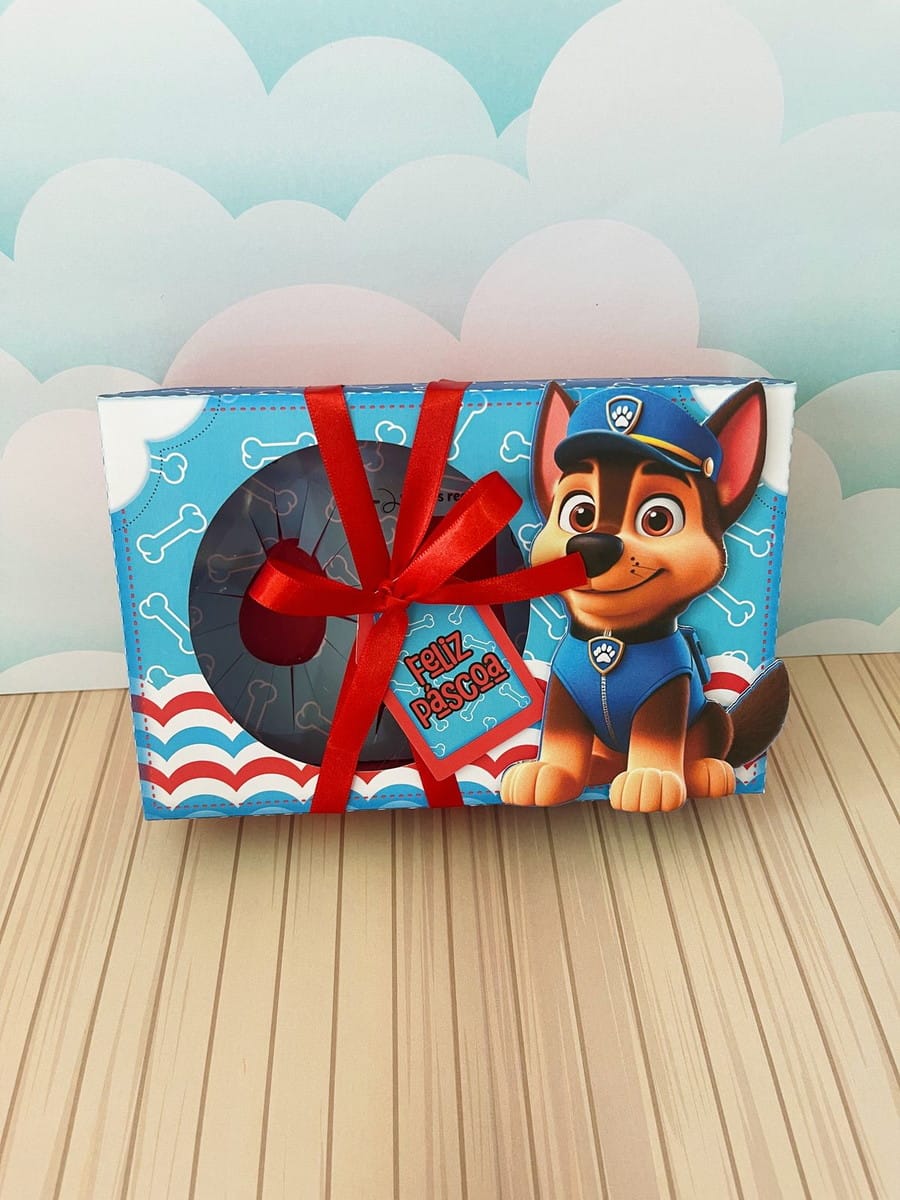 Caixa Mini Confeiteiro Patrulha Canina Digital 2 Caixa retangular decorada com cachorro, laço vermelho e etiqueta com texto Feliz Páscoa.