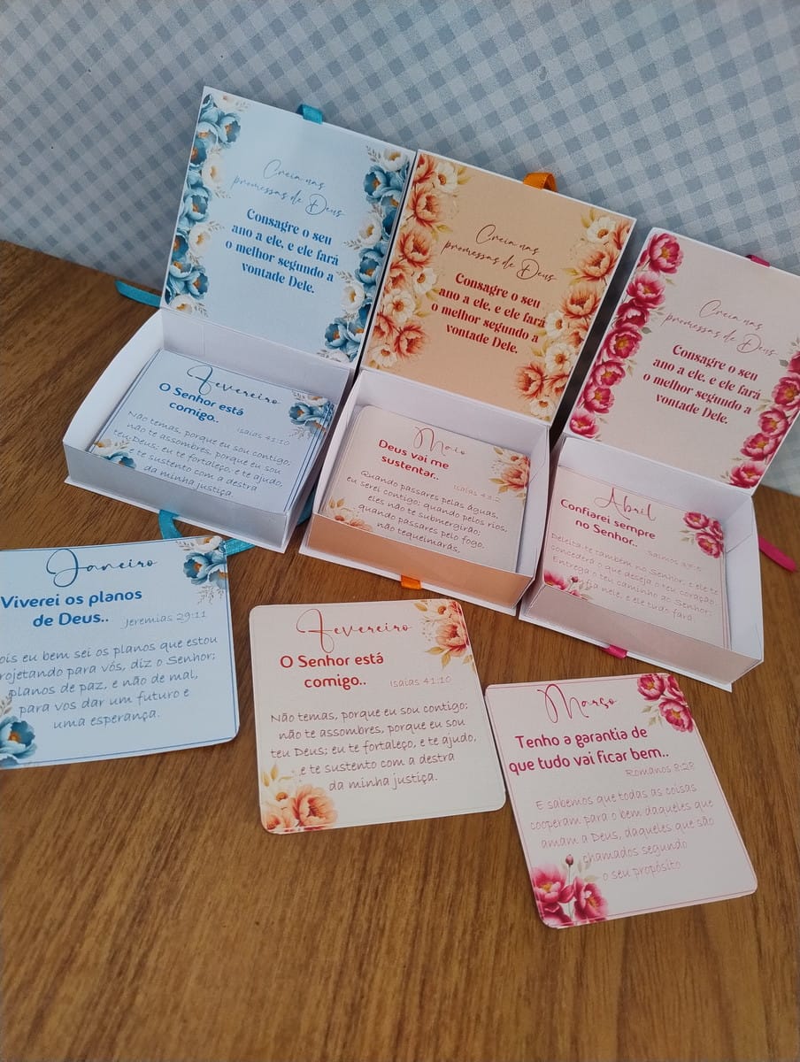 Kit Caixas 2025 PNG PDF Tema Floral Religioso 2 Caixas e cartões com versículos bíblicos e motivos florais em uma superfície de madeira.