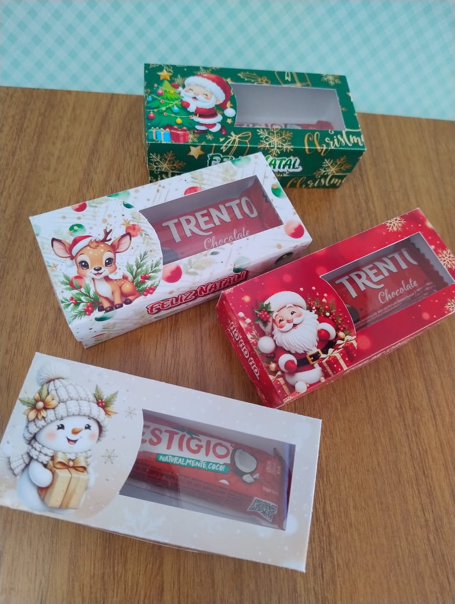 Caixinhas de Natal Vintage em PNG e PDF 2 Quatro caixas de doces decoradas com temas natalinos sobre uma mesa de madeira.