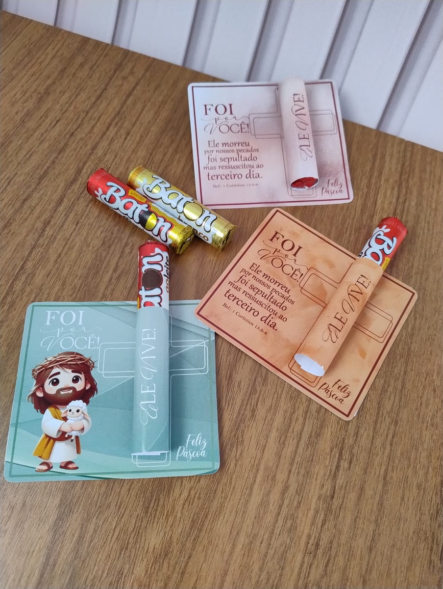 Card Baton Chocolate Páscoa Arte Digital para Imprimir 2 Cartões de papel personalizados com chocolates cilíndricos sobre uma superfície de madeira clara.