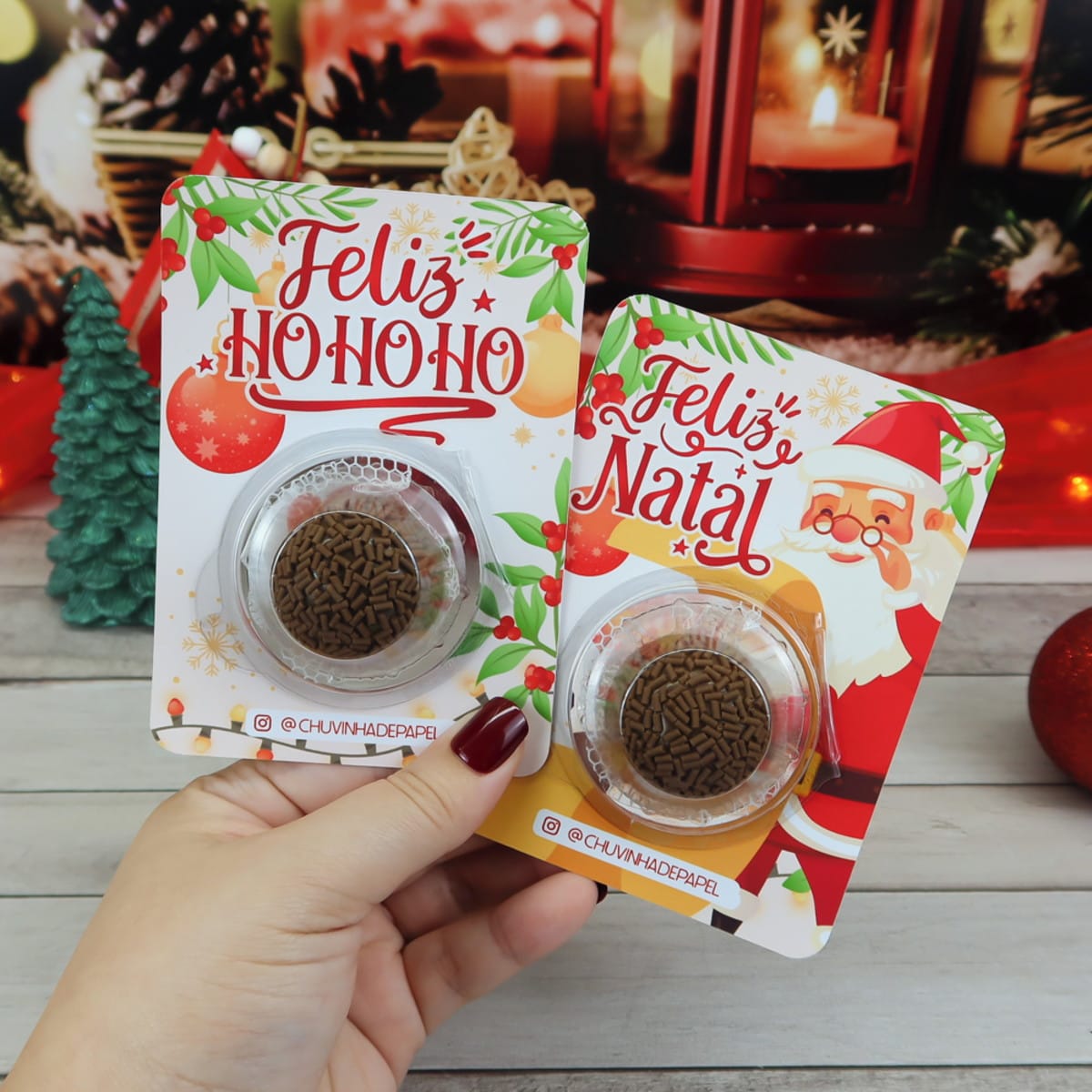Card Blister Natal 2023 Digital para Embalagens Festivas 2 Mão segurando dois cartões de Natal decorados com doces embalados em plástico.