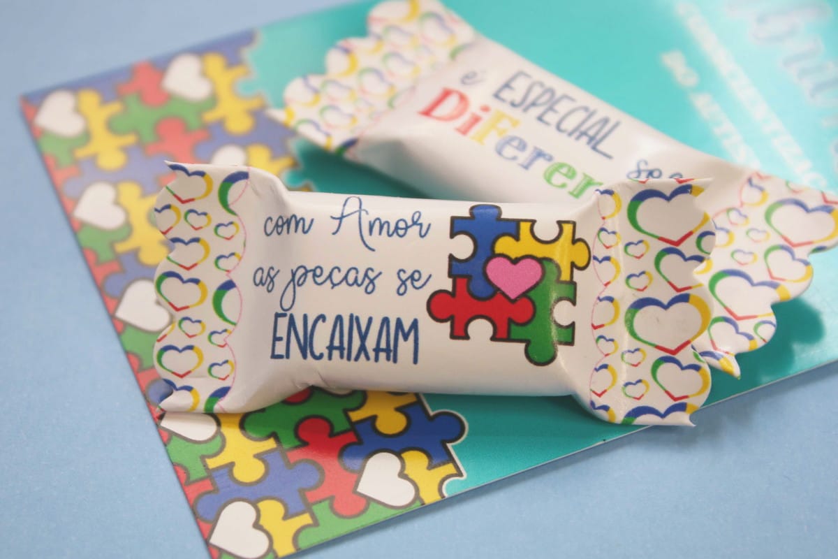 Card e Balas Autismo Arquivo Digital para Imprimir 3 Arte digital com embalagens e fundo de quebra-cabeça colorido, com corações e texto.