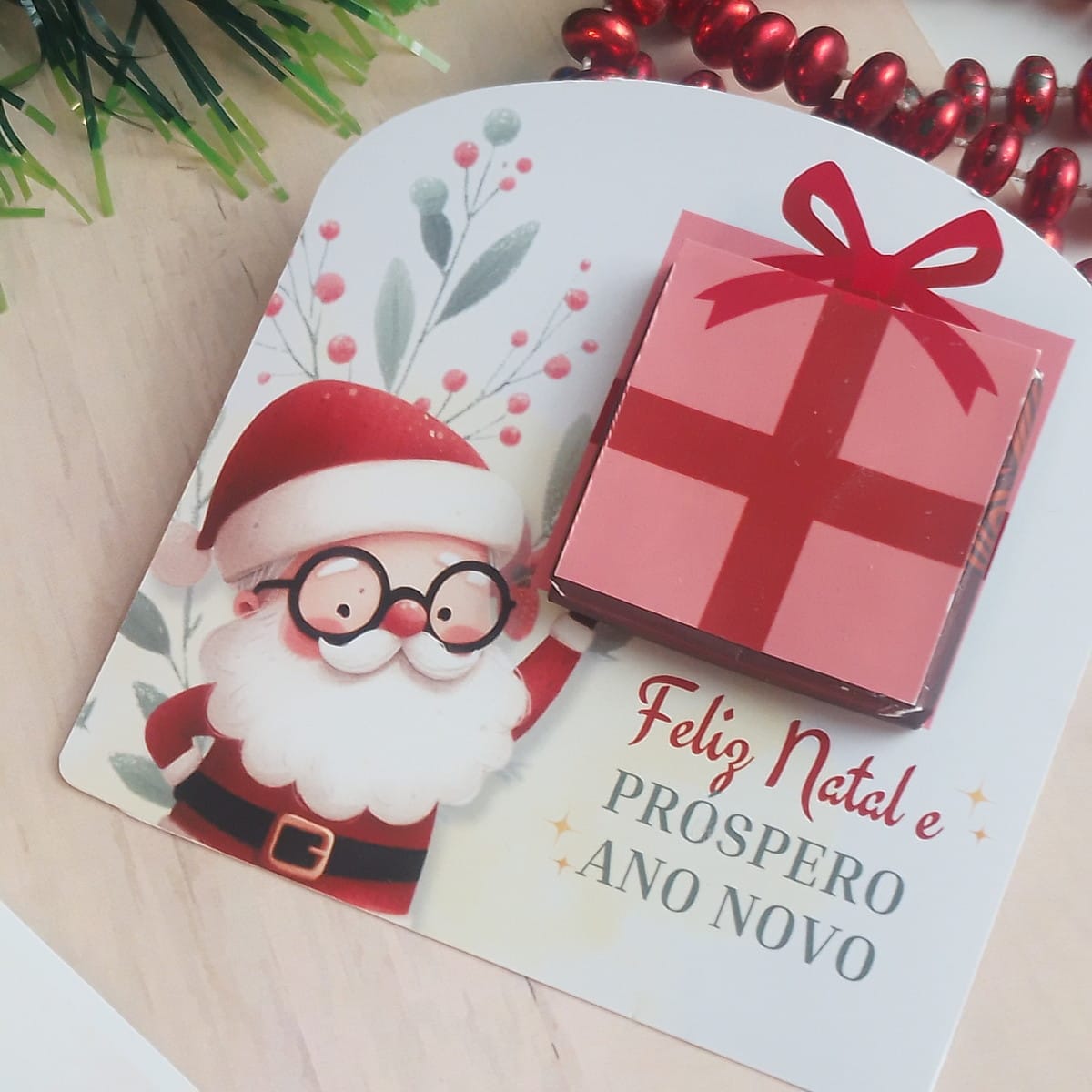 Card Natal para Mini Chocolate com Artes em PDF PNG e Canva 5 Arte digital de cartão de Natal com Papai Noel e presente rosa.