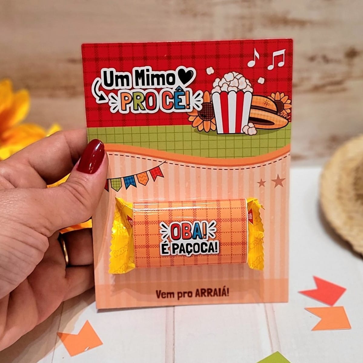 Card Paçoca Festa Junina PNG e PDF para Imprimir 4 Mão segurando um cartão personalizado com paçoca para festa temática junina.