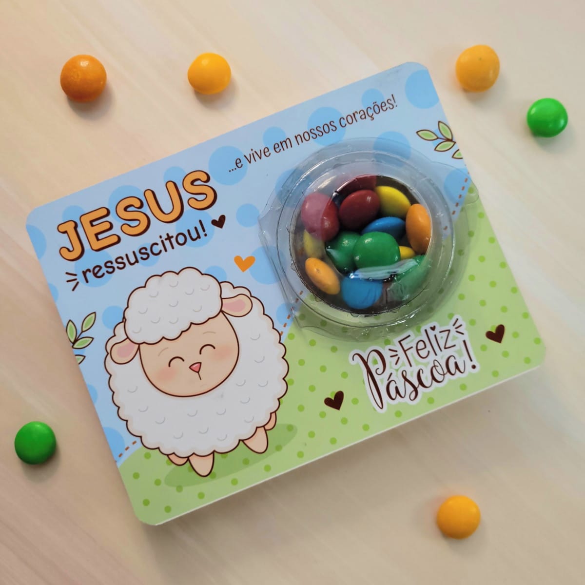 Cartão Blister Brigadeiro Páscoa Arquivo Digital para Corte 3 Cartão ilustrado com ovelha, doces coloridos e mensagem sobre Páscoa na mesa.