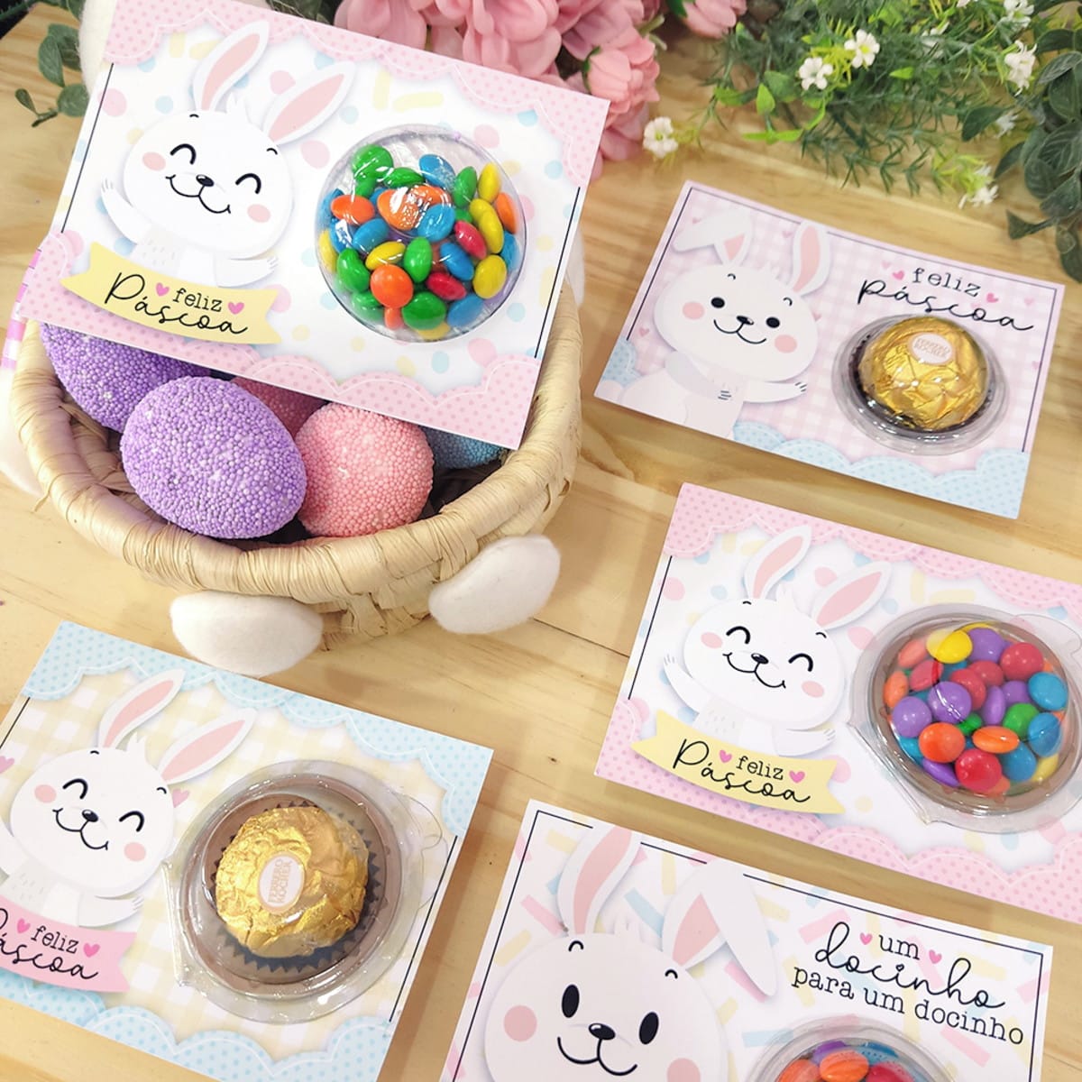Cartão Blister Coelhinho de Páscoa Digital 3 Cartões de páscoa personalizados com coelhinhos e doces em embalagens plásticas sobre mesa.