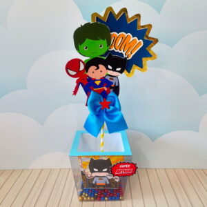 Arte digital para centro de mesa com ilustrações de super-heróis e balão 'BOOM!'.
