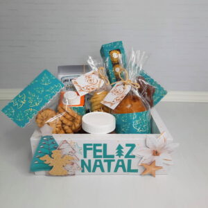Cesta decorada com tema natalino contendo diversos alimentos embalados para presente festivo.