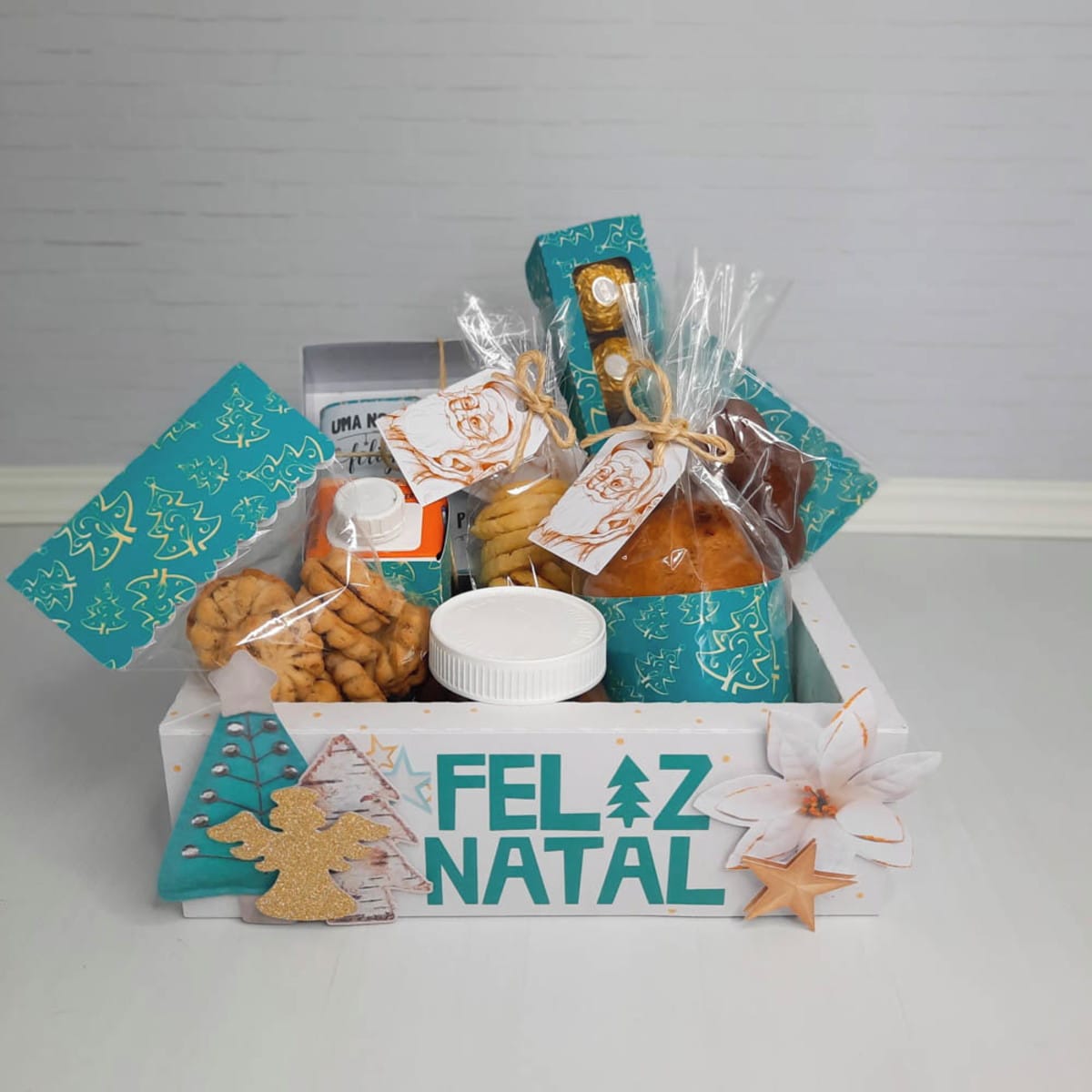 Cesta Natalina Verde em Arquivo de Corte Digital 1 Cesta decorada com tema natalino contendo diversos alimentos embalados para presente festivo.