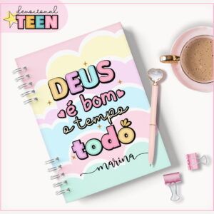 Caderno espiral colorido com capa de nuvens e frase em destaque, caneta e xícara.