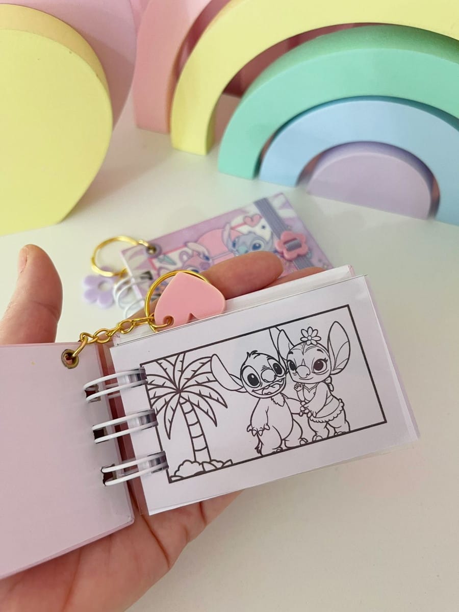 Kit Colorir Stitch Mini Digital para Projetos 4 Mão segurando um mini caderno artesanal com desenhos de personagens para colorir.