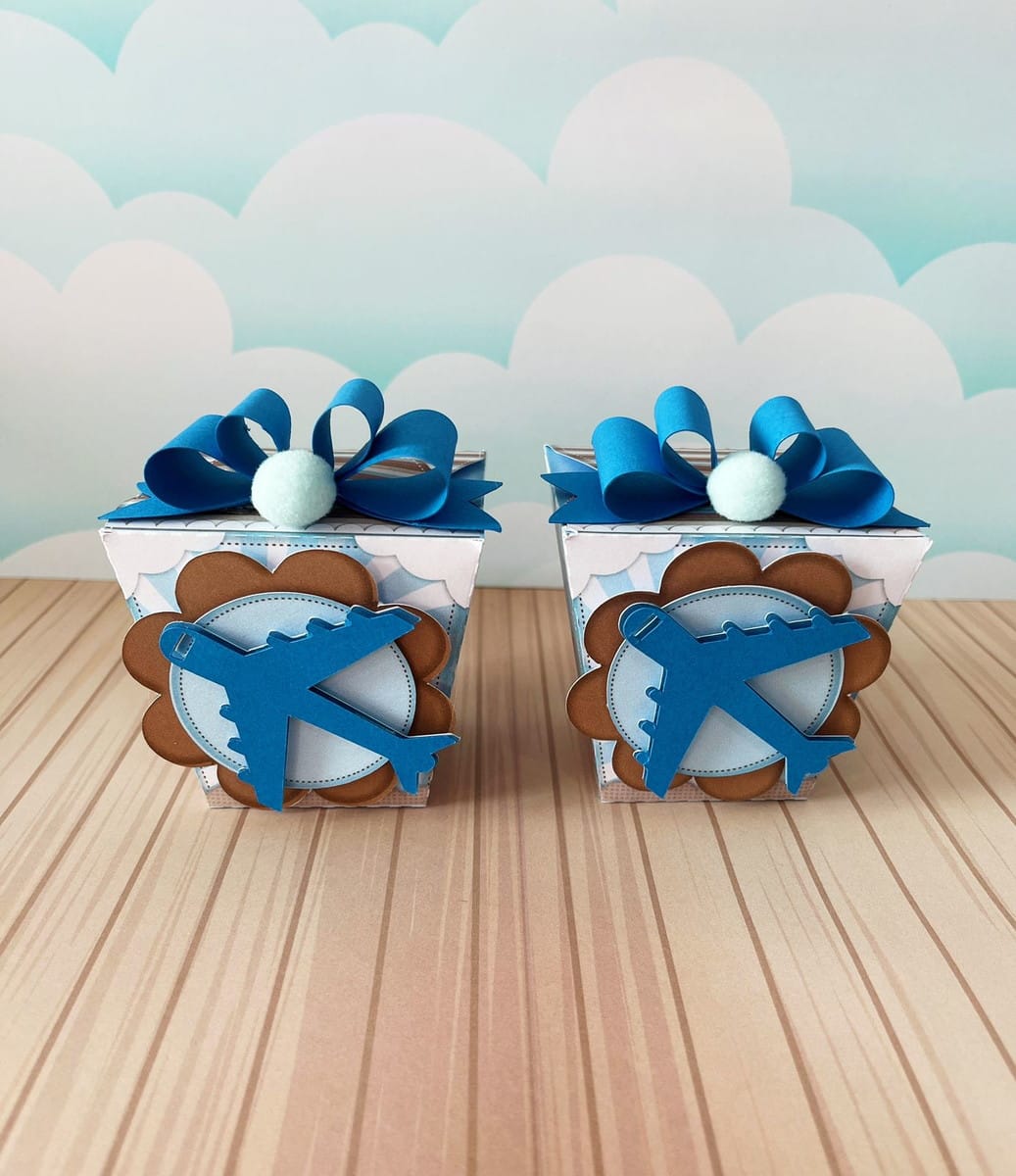 Kit de Corte Festa O Tempo Voa Menino Arquivo Digital 5 Duas caixas de papel com decoração de avião e laço azul no topo.