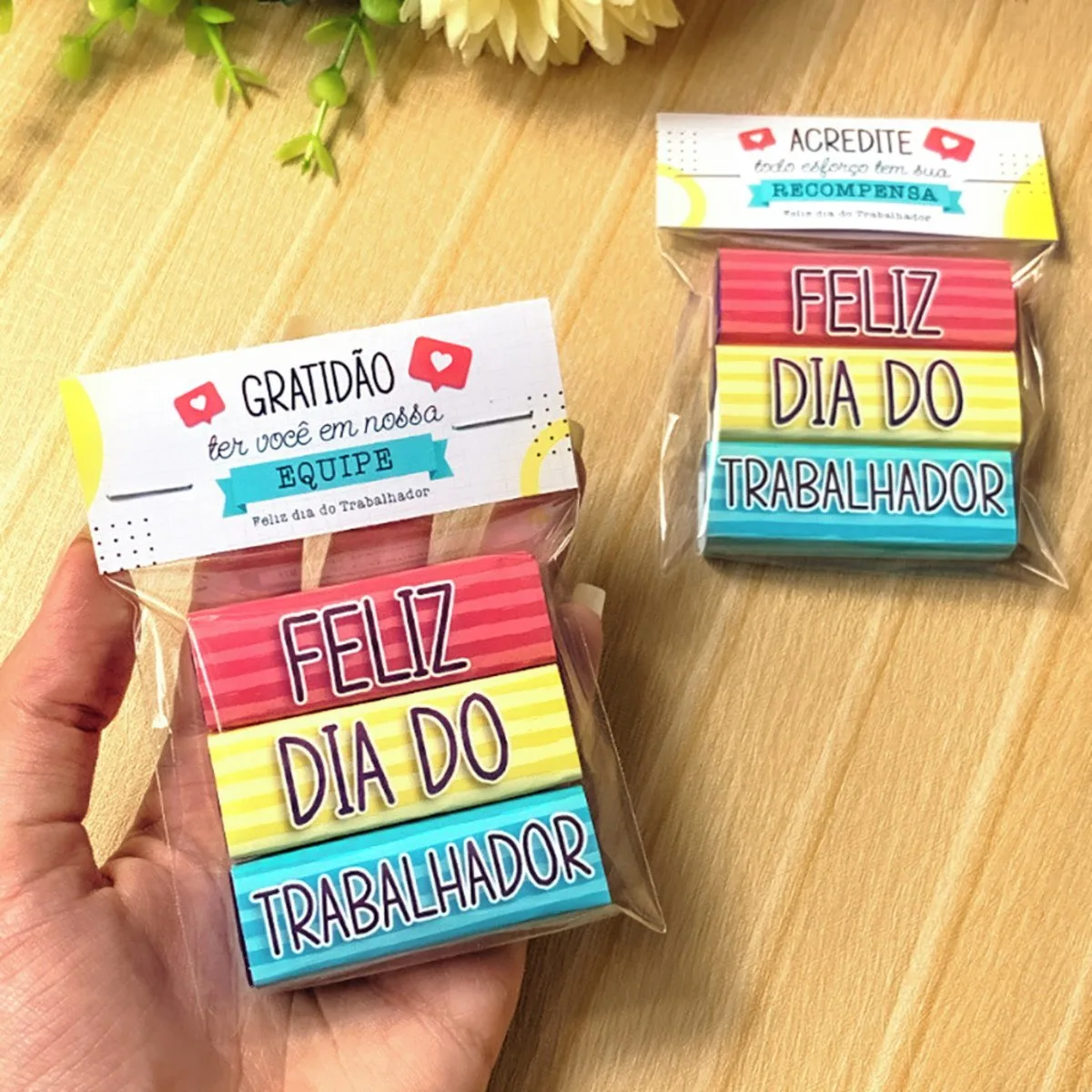 Dois pacotes embalados em plástico com doces empilhados coloridos com mensagens impressas.
