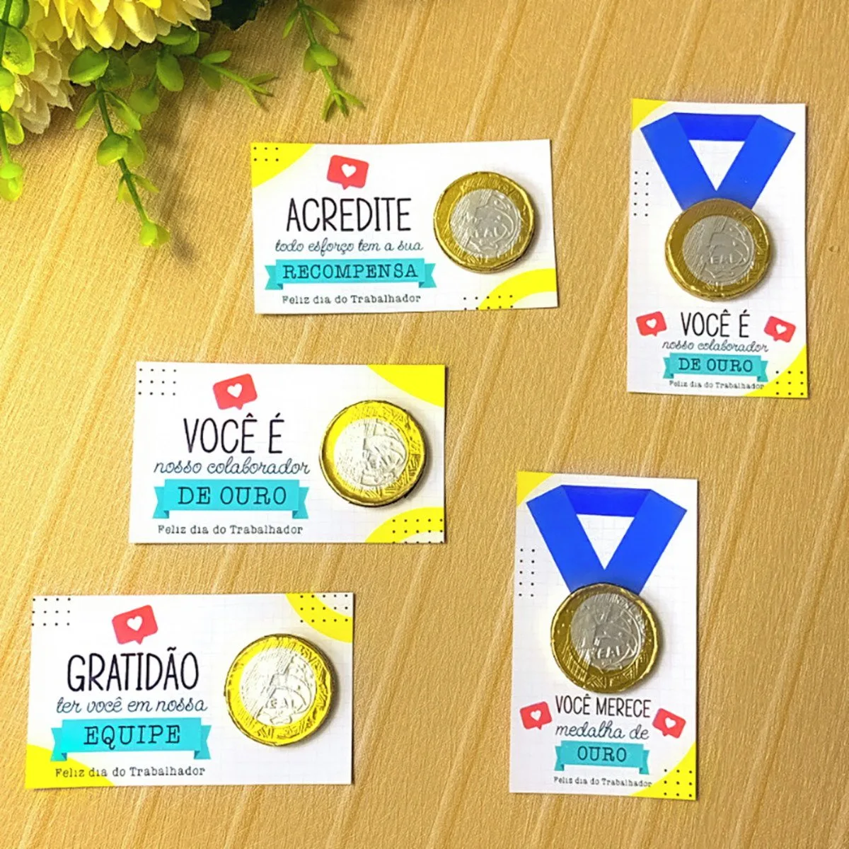 Cartões temáticos coloridos com moedas de chocolate e medalhas sobre fundo de madeira.