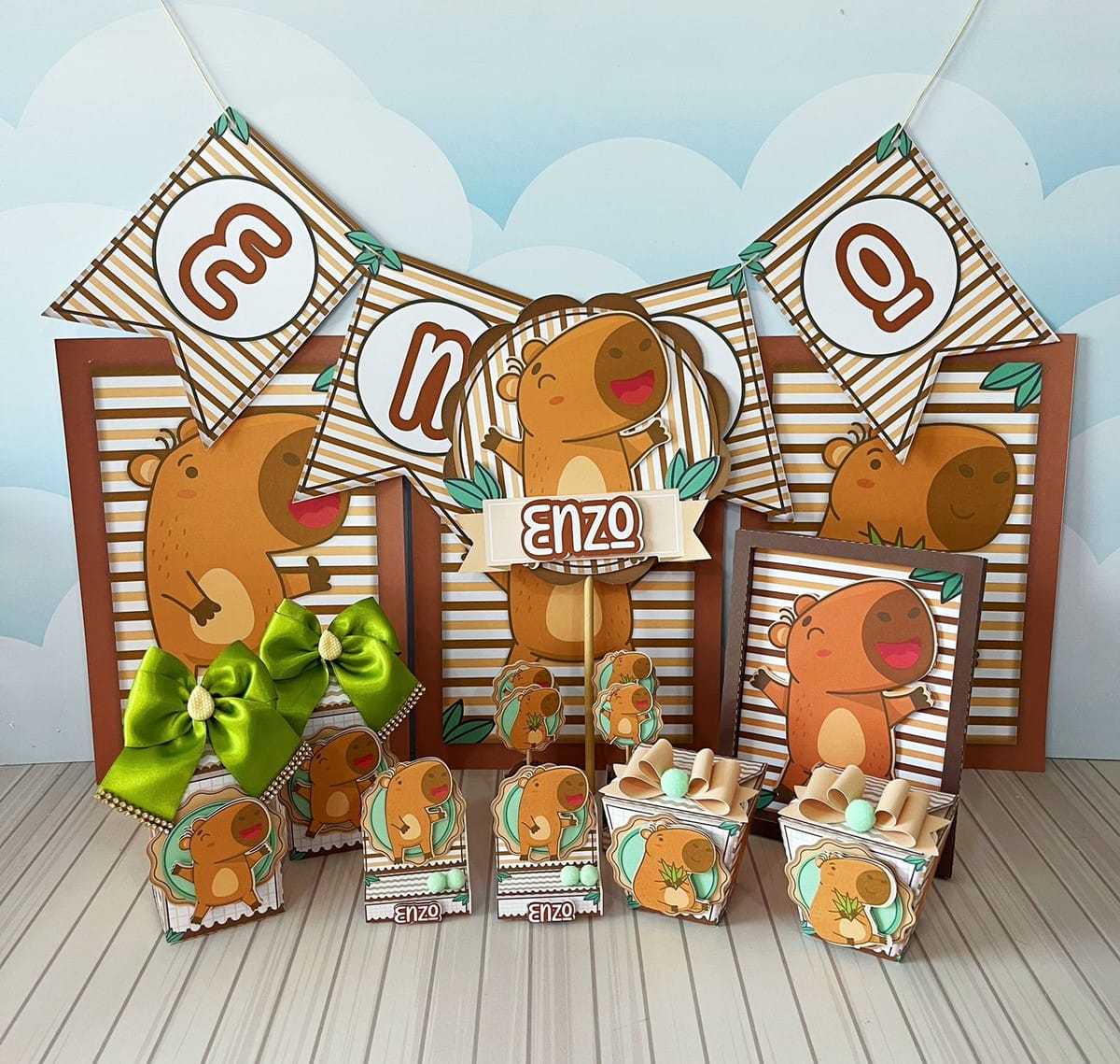 Kit Digital Festa Capivara Menino para Corte 1 Decoração de festa infantil personalizada com tema de capivara, incluindo bandeirolas e lembrancinhas de papel.