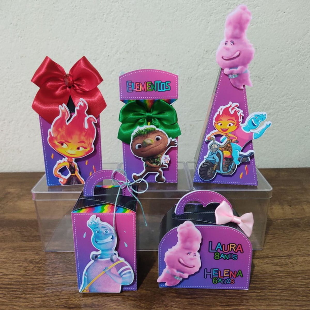 Kit Digital Festa Elementos Studio para Maquina de Corte 1 Conjunto de caixas decoradas com temas coloridos e personagens animados em cima de suportes transparentes