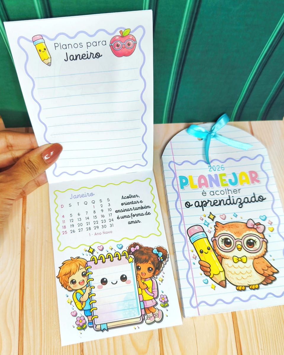 Kit Digital Mimos Escolares Volta às Aulas 2026 2 Mão segura um bloco de notas aberto com desenhos escolares coloridos e calendário.
