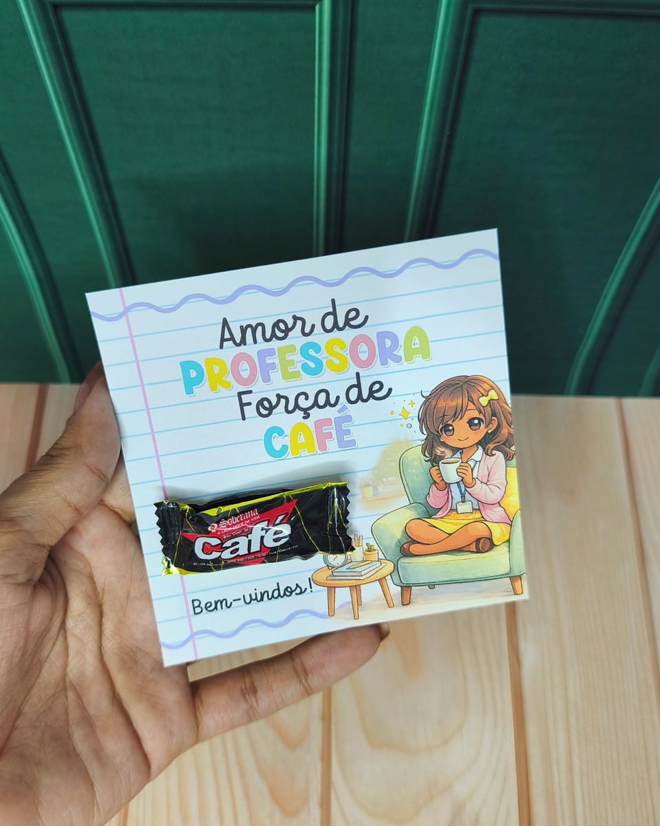 Kit Digital Mimos Escolares Volta às Aulas 2026 5 Mão segurando um cartão com mensagem em português e um doce preso na frente.