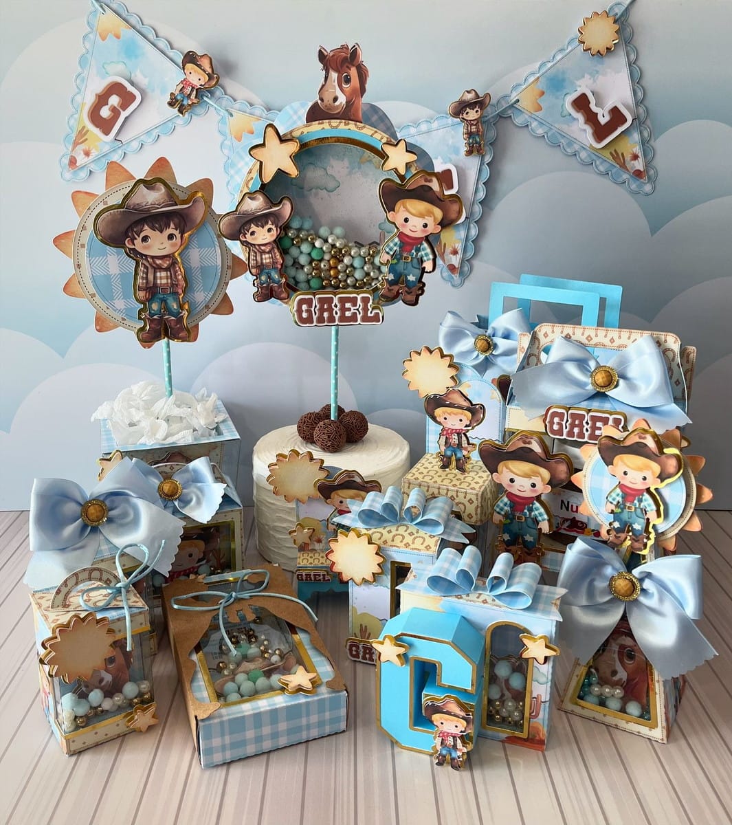 Kit Festa Cowboy Menino Studio e PDF para Personalizar 1 Kit de festa infantil com tema de cowboy, incluindo toppers e caixas decoradas.