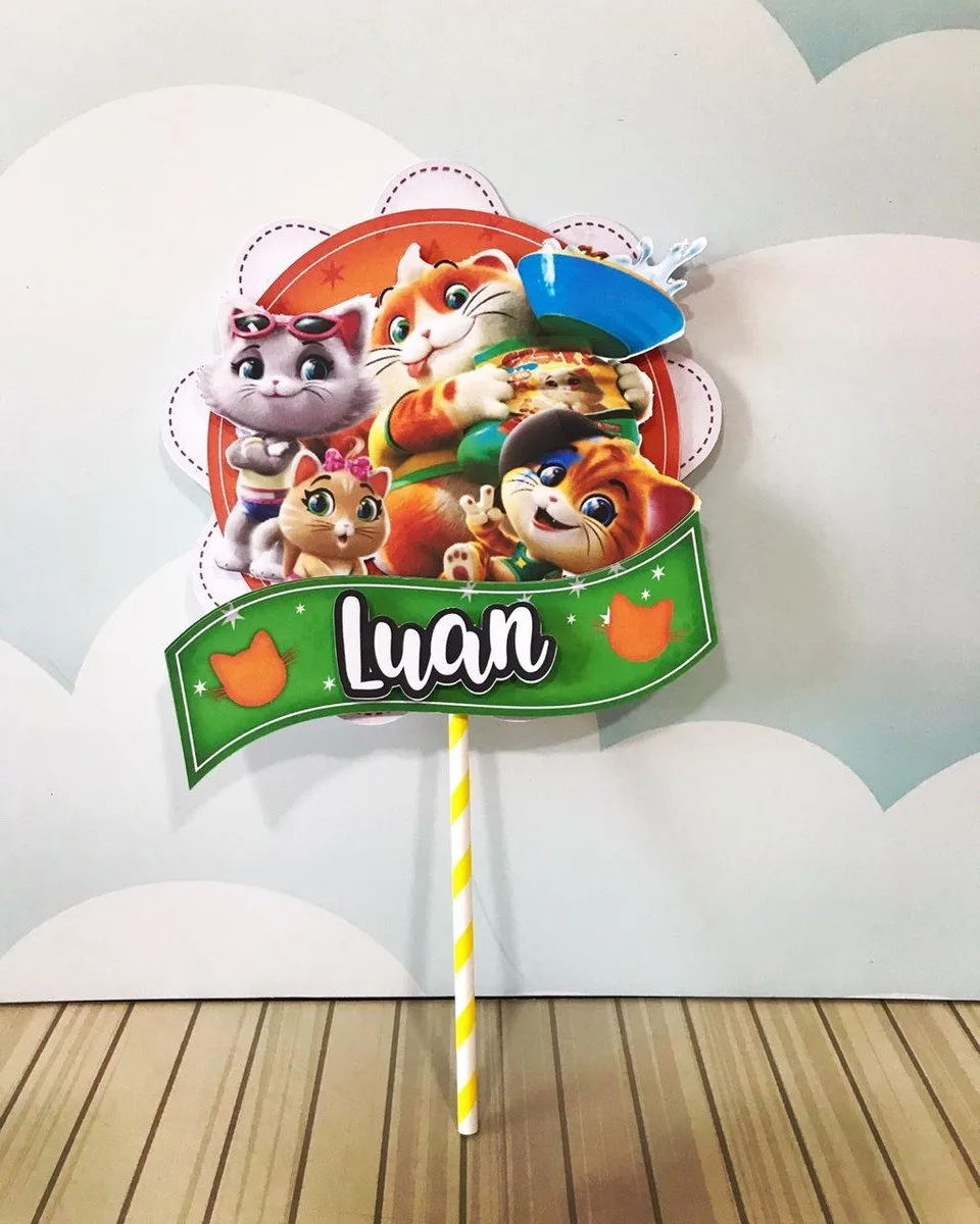 Topo de bolo com desenho de gatos coloridos e nome personalizado em fundo claro.