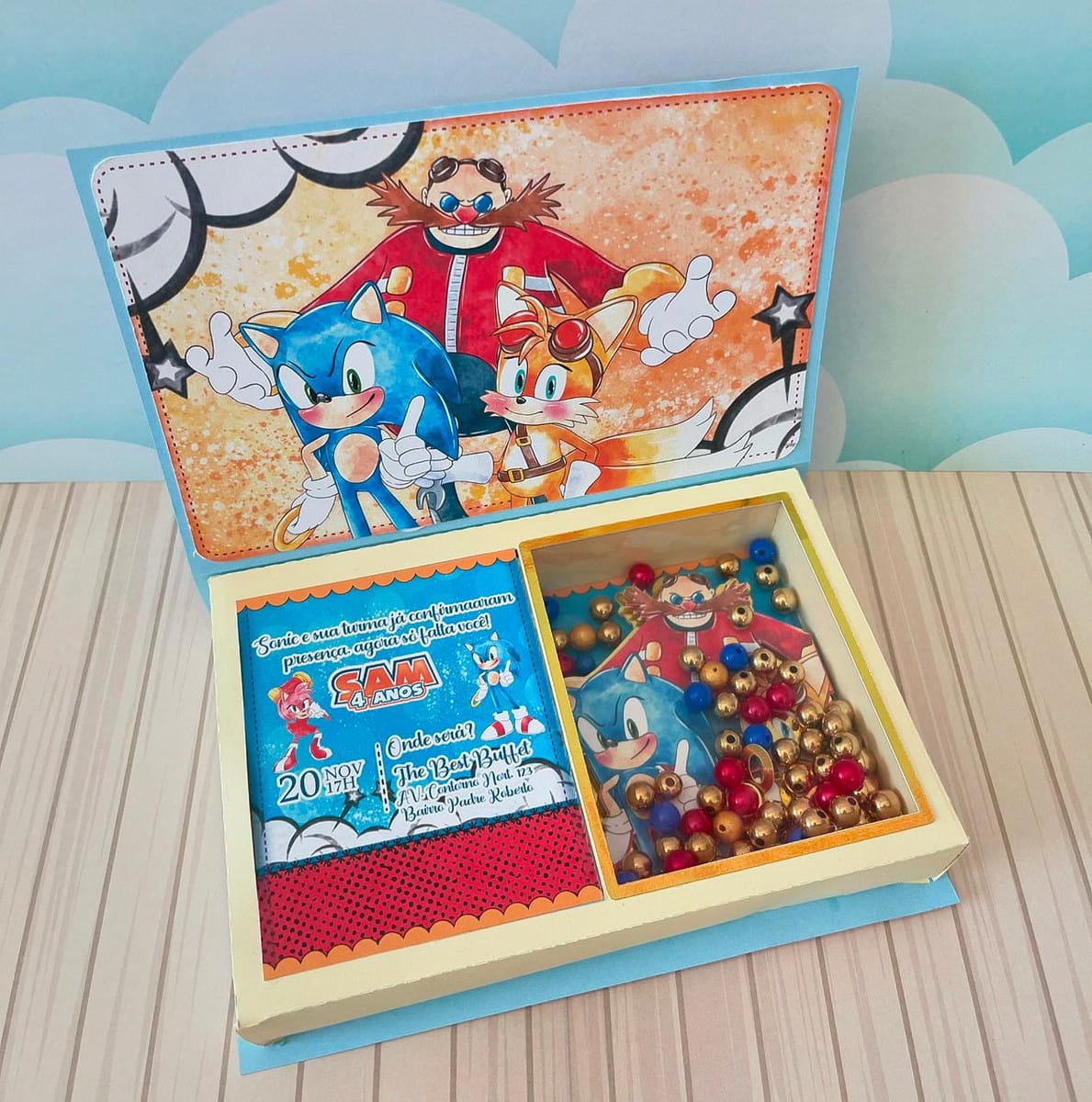 Kit Festa Sonic Luxo Digital com Studio e PDF 2 Caixa aberta com arte de ouriço azul, raposa laranja, vilão e miçangas coloridas.