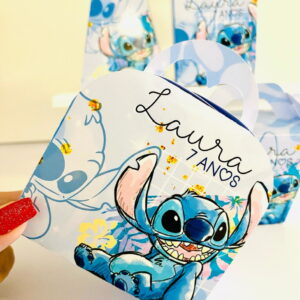 Mão segurando caixa de papel com estampa de criatura azul sorrindo
