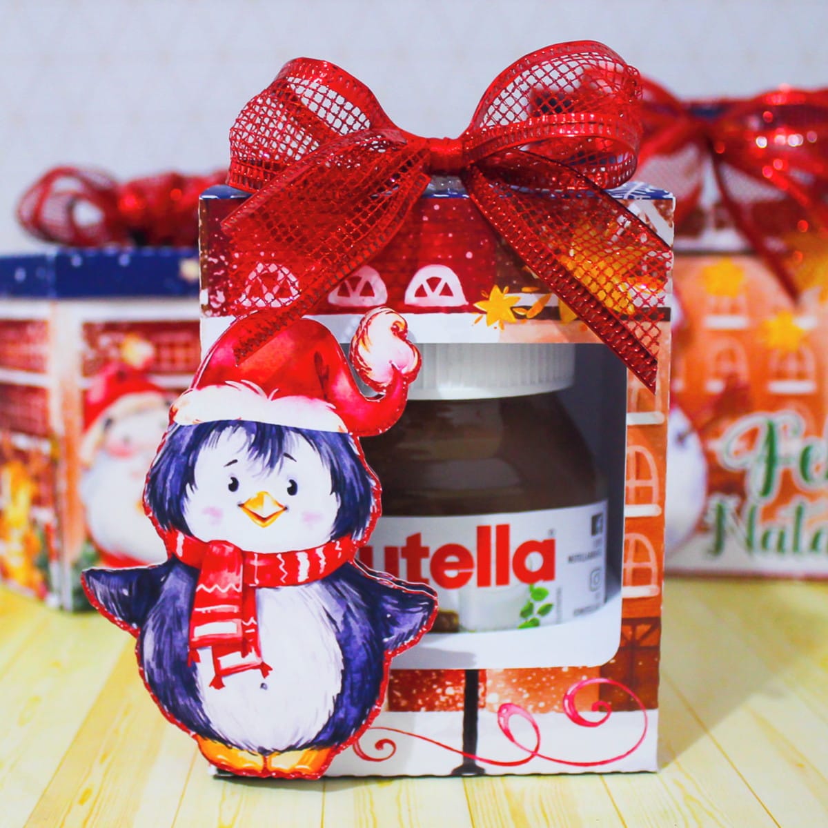 Kit Natal Aquarela Digital com Embalagens para Doces 4 Caixa de presente com tema natalino, laço vermelho e pinguim de gorro.
