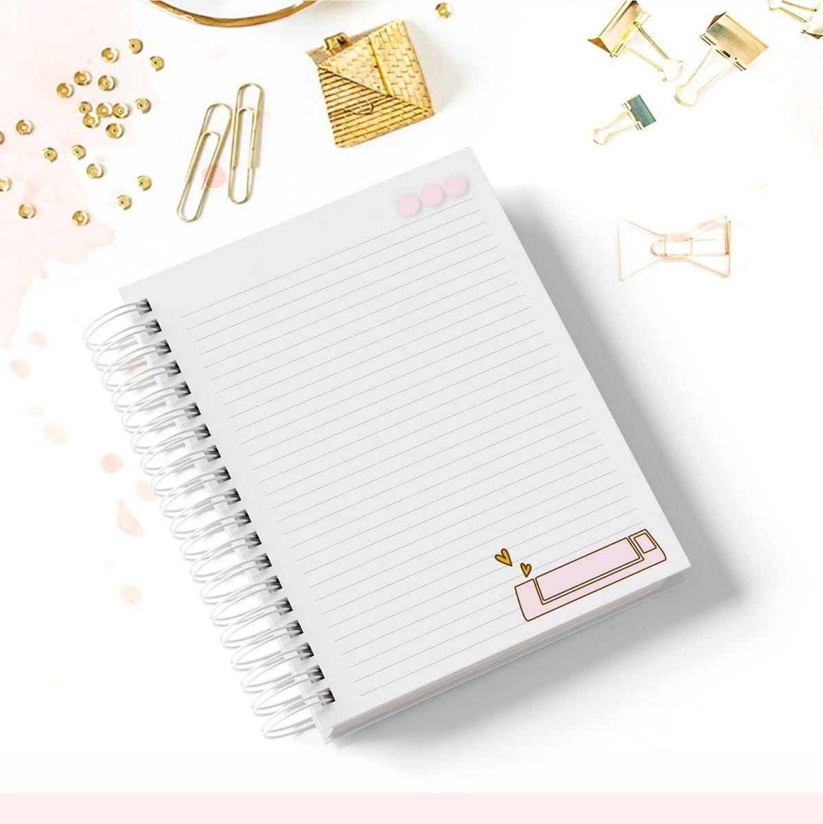 Kit Papelaria Artesã Digital com Stickers e Desk Planner 2 Caderno de espiral branco com folhas pautadas sobre uma mesa branca com acessórios.