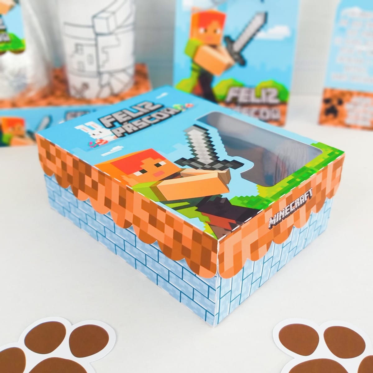 Kit Páscoa Minecraft Arquivo Digital para Confeiteiros 4 Caixa retangular decorada com temática de blocos e personagens pixelados em cima de uma mesa.