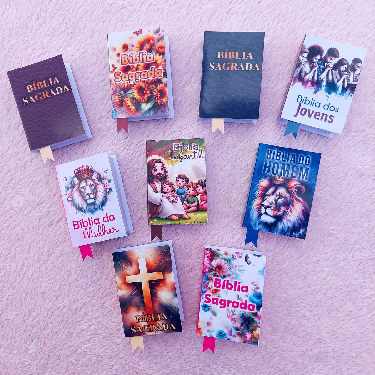 Lembrancinha Bíblia Promessas da Mulher Arquivo Digital 2 Oito representações digitais de livros religiosos com capas variadas em fundo rosa.