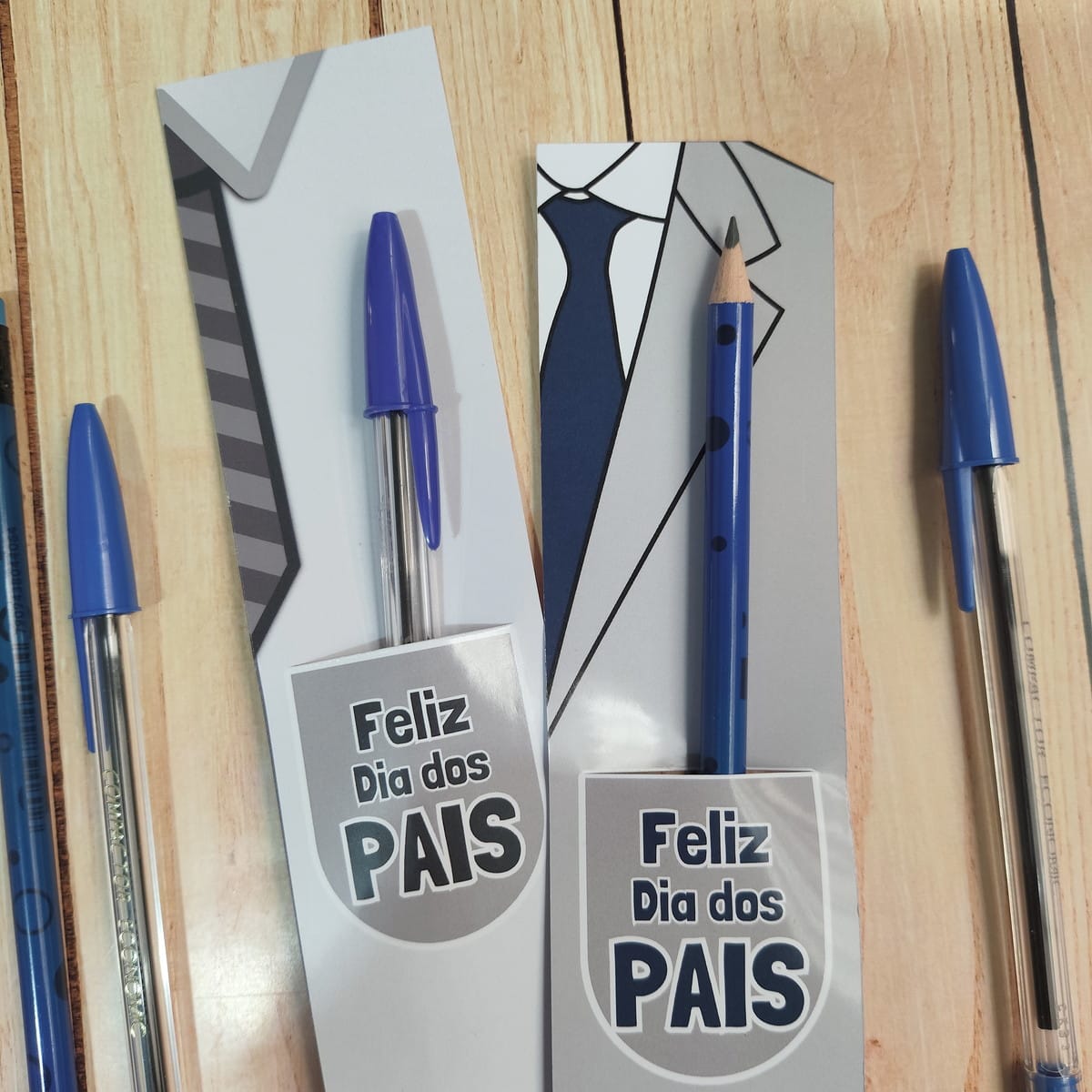 Lembrancinhas Dia dos Pais Religiosas PNG e PDF 5 Cartões temáticos de terno e gravata para o Dia dos Pais, com caneta e lápis azuis.