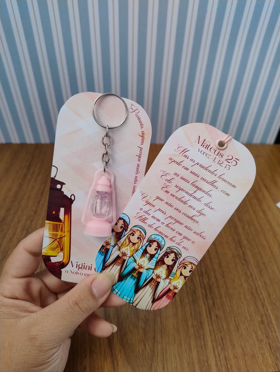 Marca Páginas Lamparina PDF e PNG Lembrancinha Infantil 3 Mão segurando dois cartões de papel decorados com ilustrações religiosas e um chaveiro.